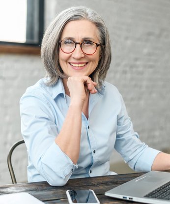 Ältere Frau im Büro am Computer