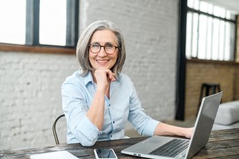 Ältere Frau im Büro am Computer