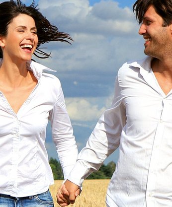 Mann und Frau sind glücklich und laufen über ein Feld