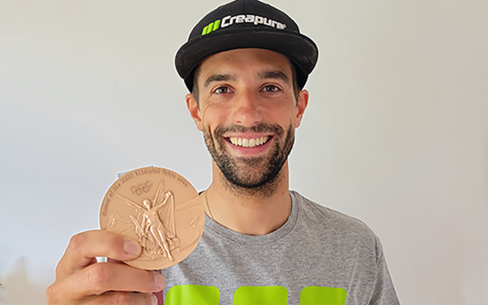 Hannes Aigner mit Olympia Medaille und Creapure Klamotten