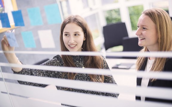 zwei Industriekauffrauen schreiben auf Post-Its