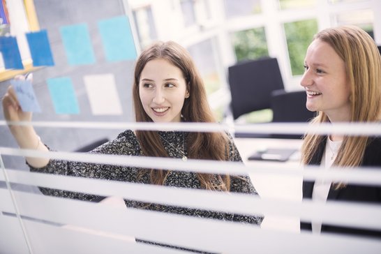 zwei Industriekauffrauen schreiben auf Post-Its