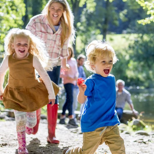 Kinder spielen draußen am Fluss