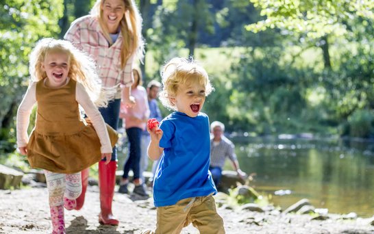 Kinder spielen draußen am Fluss