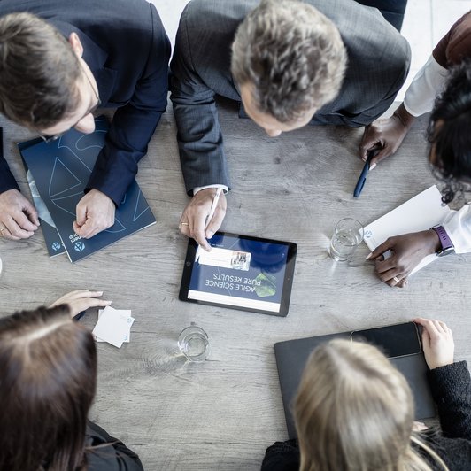 Meeting Alzchem Personen am Tisch Aufnahme von oben