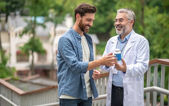 Mediziner mit Nahrungsergänzungsmittel in der Hand
