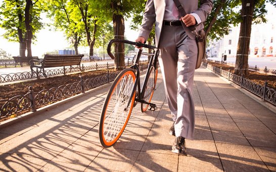 Mann schiebt ein Fahrrad bei schönem Wetter