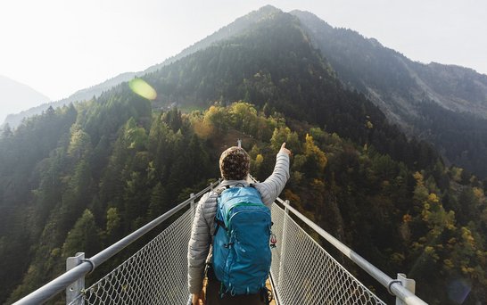 Mann auf Berg, zeigt in die Berge