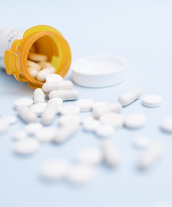 Weiße Tabletten in orangener Dose