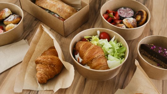 Croissants, belegte Brötchen, Kuchen und Obst 